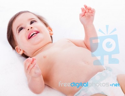 Playful Baby Lying With Has Hands Up Stock Photo