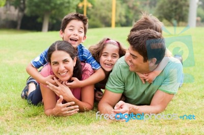 Playful Family Lying Outdoors And Smiling Stock Photo