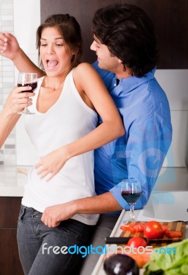 Playful Young Couple Enjoying Their Love In Kitchen Stock Photo