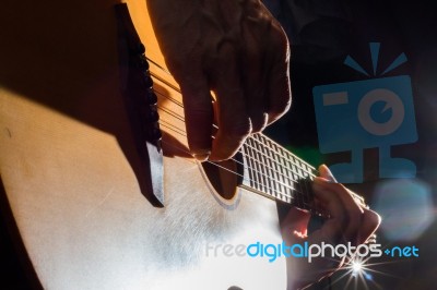 Playing Acoustic Guitar On Low-key Lighting Background Stock Photo