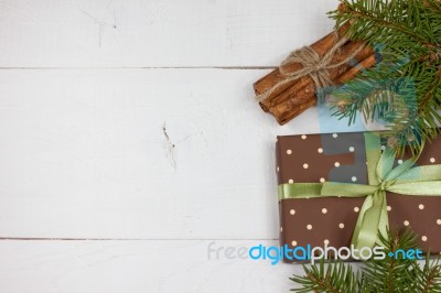 Polka Dot Gift With Christmas Decoration With Cinnamon And Pine Branches On White Wood Background Stock Photo