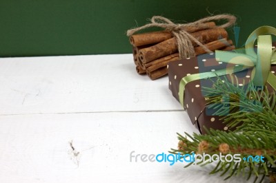 Polka Dot Gift With Christmas Decoration With Cinnamon And Pine Branches On White Wood Background Stock Photo