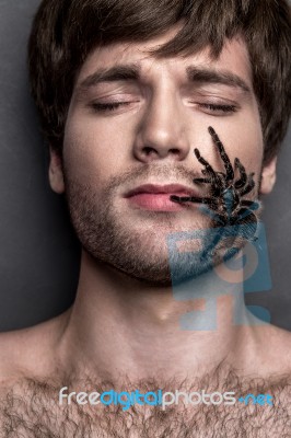 Portrait Of A Young Handsome Man With Spider On His Face Stock Photo