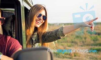 Portrait Of Beautiful Girl On Car Roadtrip Pointing Forward Stock Photo