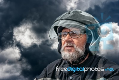 Portrait Of Elderly Motorcyclist On Gloomy Dark Cloudy Day Stock Photo