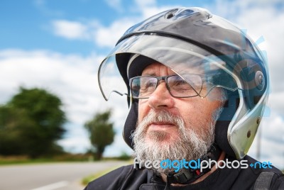 Portrait Of Elderly Motorcyclist Wearing A Jacket And Glasses Wi… Stock Photo