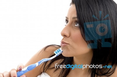 Portrait Of Female Looking Upward With Toothbrush Stock Photo
