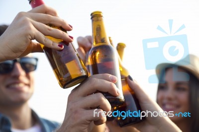Portrait Of Group Of Friends Toasting With Bottles Of Beer Stock Photo