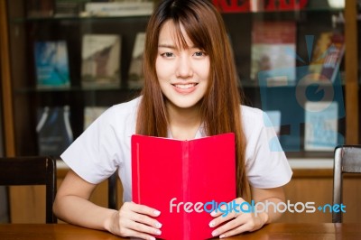 Portrait Of Thai Adult Student University Uniform Beautiful Girl Reading Red Book Stock Photo