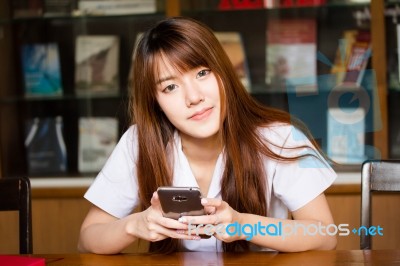 Portrait Of Thai Adult Student University Uniform Beautiful Girl Using Her Smart Phone Stock Photo