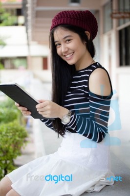 Portrait Of Thai Teen Beautiful Girl Using Her Tablet Stock Photo