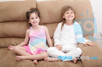 Portrait Of Two Girls In The Sofa Stock Photo