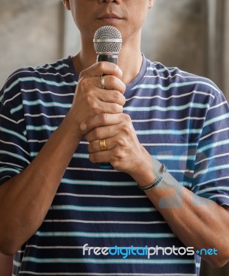 Portrait Of Young Asian Man And Microphone In Hand Stock Photo