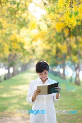 Portrait Of Young Beautiful Asian Woman Standing In Yellow Flowe… Stock Photo