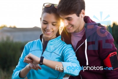 Portrait Of Young Couple Using They Smartwatch After Running Stock Photo Portrait Of Young Couple Using They Smartwatch After Running Stock Photo
