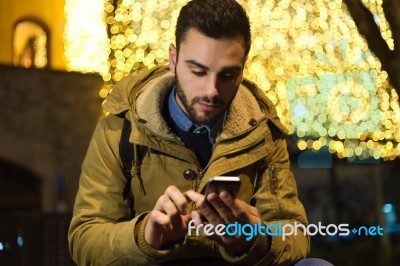 Portrait Of Young Man Using His Mobile Phone On The Street At Ni… Stock Photo