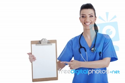 Portrait Of Young Nurse Pointing Blank Clipboard Stock Photo