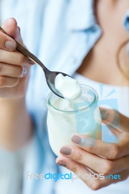 Portrait Of Young Woman Eating Yogurt Stock Photo