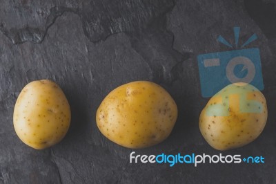Potatoes On The Dark Stone Table Top View Stock Photo