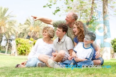 Potrait Of Grandfather Pointing With Family Stock Photo