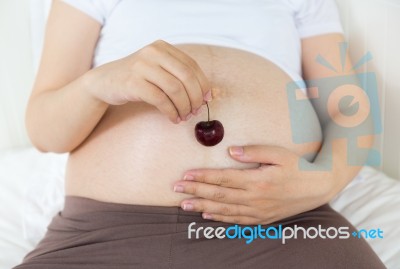 Pregnant Belly With Cherry Stock Photo
