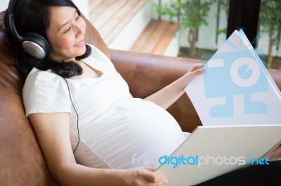 Pregnant Woman Listen To The Music Stock Photo