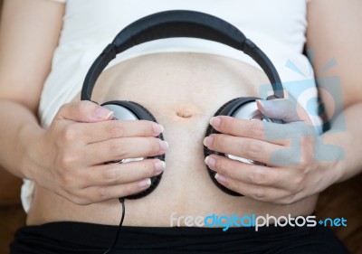 Pregnant Woman Listen To The Music Stock Photo