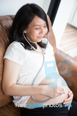 Pregnant Woman Using Stethoscope Stock Photo
