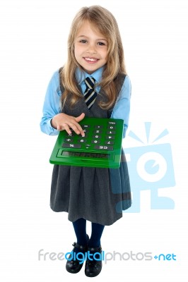 Pretty Child In School Uniform Using Calculator Stock Photo