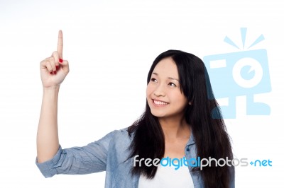 Pretty Girl Looking And Pointing Upwards Stock Photo