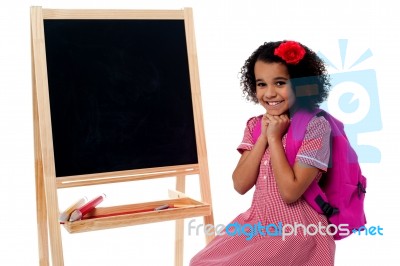 Pretty Girl Sitting Near Blank Chalk Board Stock Photo