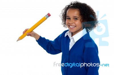 Pretty School Kid Facing Camera With Pencil In Hand Stock Photo