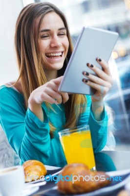 Pretty Woman Using Tablet While Having Breakfast In Coffee Shop Stock Photo
