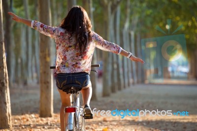 Pretty Young Girl Riding Bike In A Forest Stock Photo
