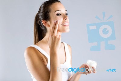 Pretty Young Woman Applying Body Cream. Isolated On Gray Backgro… Stock Photo