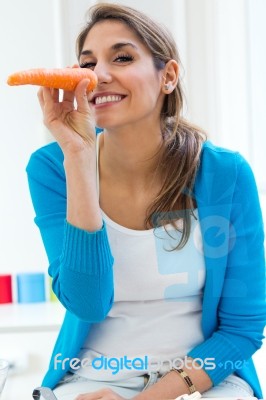 Pretty Young Woman Having Fun With A Carrot In The Kitchen Stock Photo Pretty Young Woman Having Fun With A Carrot In The Kitchen Stock Photo