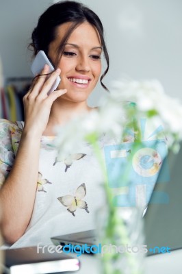 Pretty Young Woman Using Her Mobile Phone In The Office Stock Photo