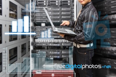 Programmer With Graph Icon In Data Center Room Stock Photo
