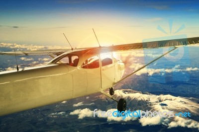 Propeller Plane Flying Over High Mountain For Traveling Theme Stock Photo