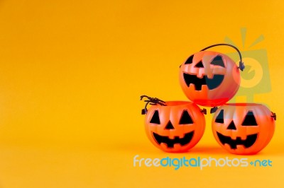 Pumpkins Bucket On Yellow Background Stock Photo