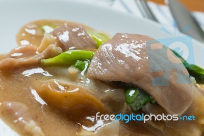 Rad Na, Famous Thai Chinese Style Wide Rice Noodle Dish With Tasty Tender Pork With Thick Gravy Sauce. Close Up Stock Photo