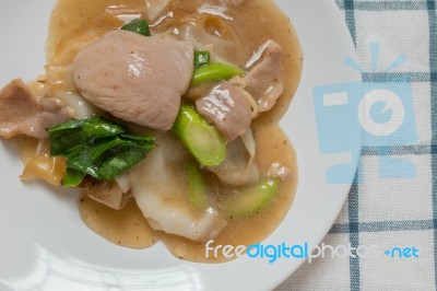 Rad Na, Famous Thai Chinese Style Wide Rice Noodle Dish With Tasty Tender Pork With Thick Gravy Sauce. Close Up Stock Photo