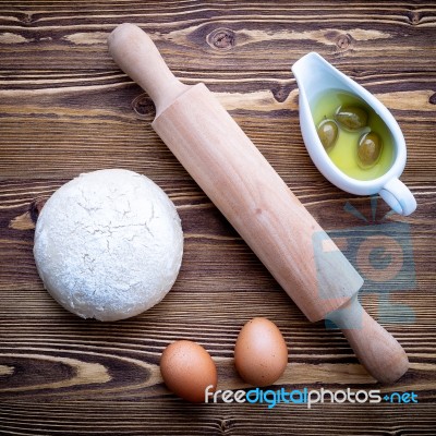 Raw Pizza Dough And Rolling Pin On Wooden Background Stock Photo