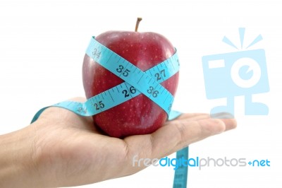 Red Apple With Tape In Hand Stock Photo