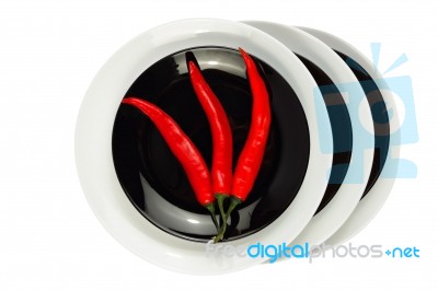 Red Chilli Peppers On Black Plate Isolated On White Stock Photo