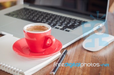 Red Coffee Cup With Notepad And Laptop Stock Photo