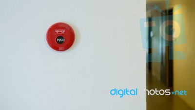 Red Fire Alarm On Wall Beside Walkway In Condominium Stock Photo