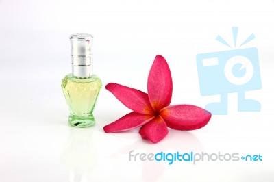 Red Flowers And Green Perfume Bottles Stock Photo
