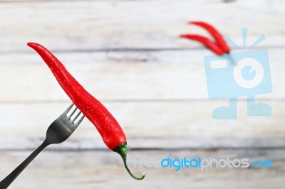 Red Hot Chili Pepper With Water Drops On Fork Stock Photo