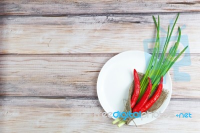 Red Hot Chilli Pepper And Green Onion On Plate Stock Photo